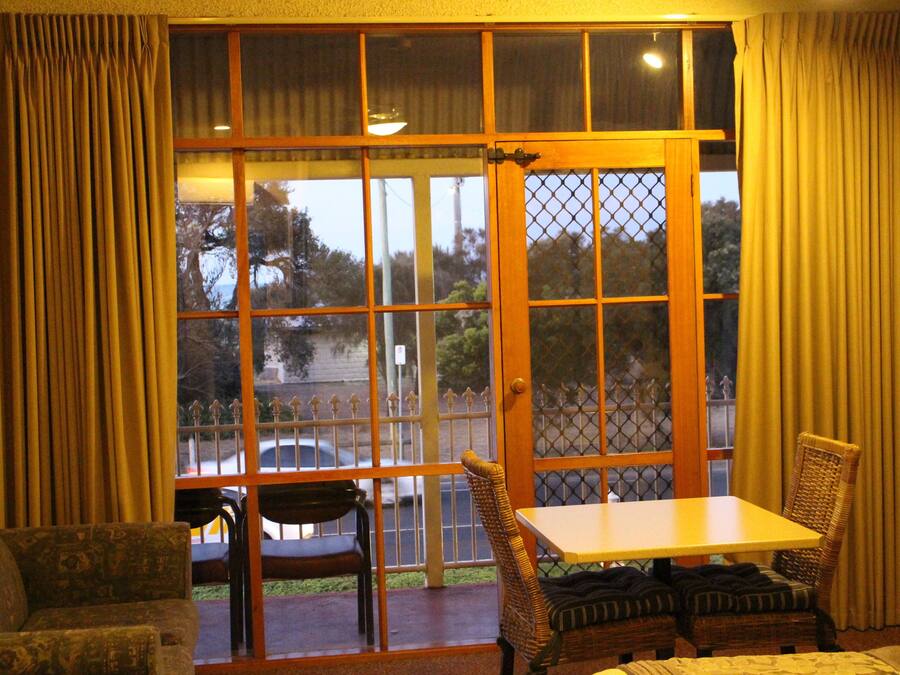 Una habitación con un ventanal grande, una mesa y dos sillas.