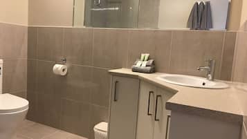 Een badkamer met toilet, wastafel en douche.
