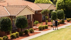 A row of brick houses with tiled roofs, surrounded by well-maintained lawns and trees. - Comfort Inn & Suites King Avenue (Sale)