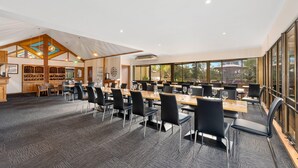 A spacious conference room with multiple tables and chairs, large windows, and a wooden ceiling structure. - Comfort Inn & Suites Riverland (Barmera)