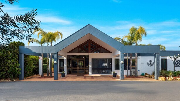 A modern building with a triangular roof, large glass entrance, and a paved driveway. - Comfort Inn & Suites Riverland (Barmera)