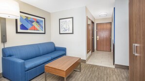 A room with a blue sofa, a wooden coffee table, and two framed abstract artworks on the wall. - Holiday Inn Express Hotel & Suites Bishop by IHG (Bishop)