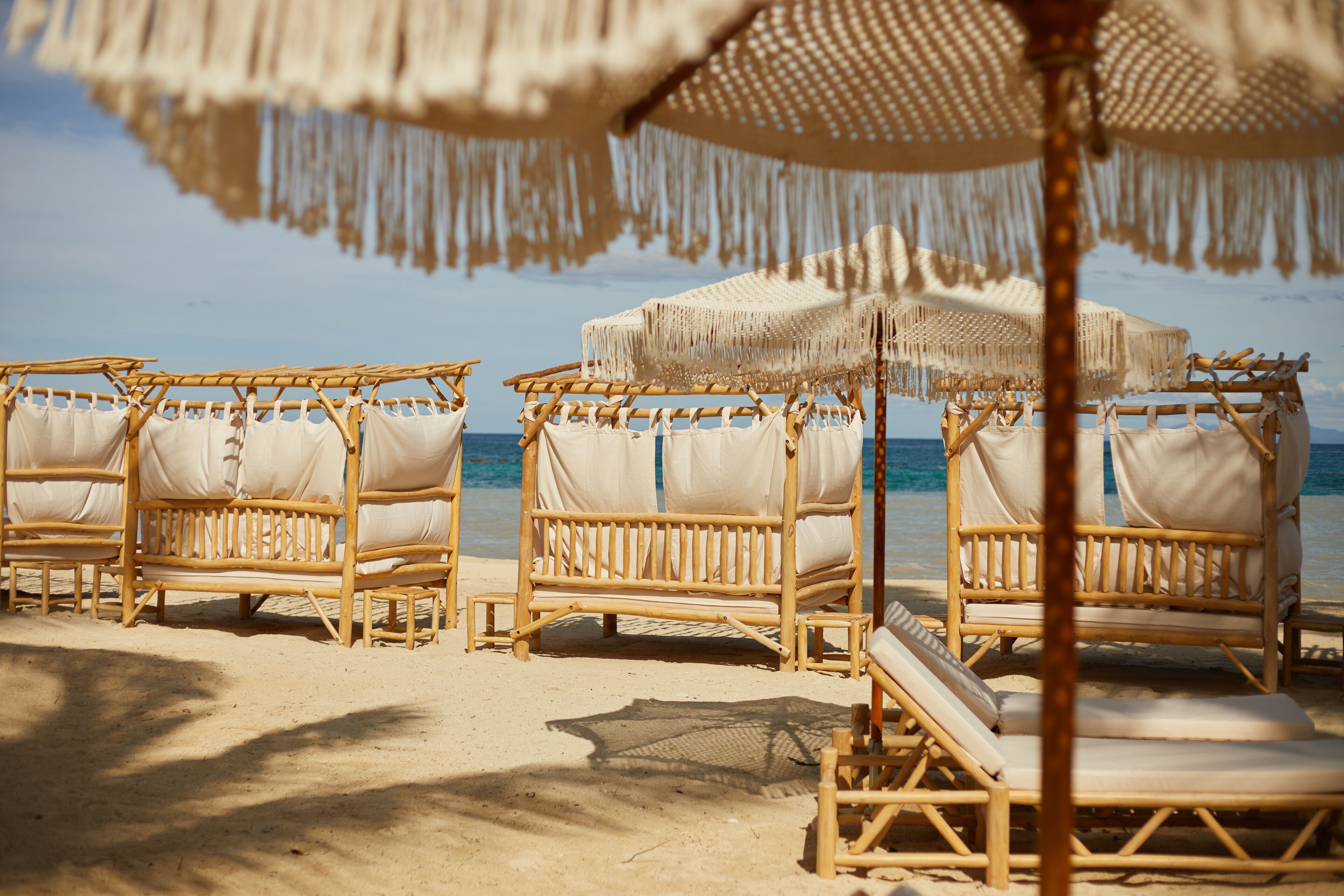 Strandstoelen met parasols op een zandstrand.