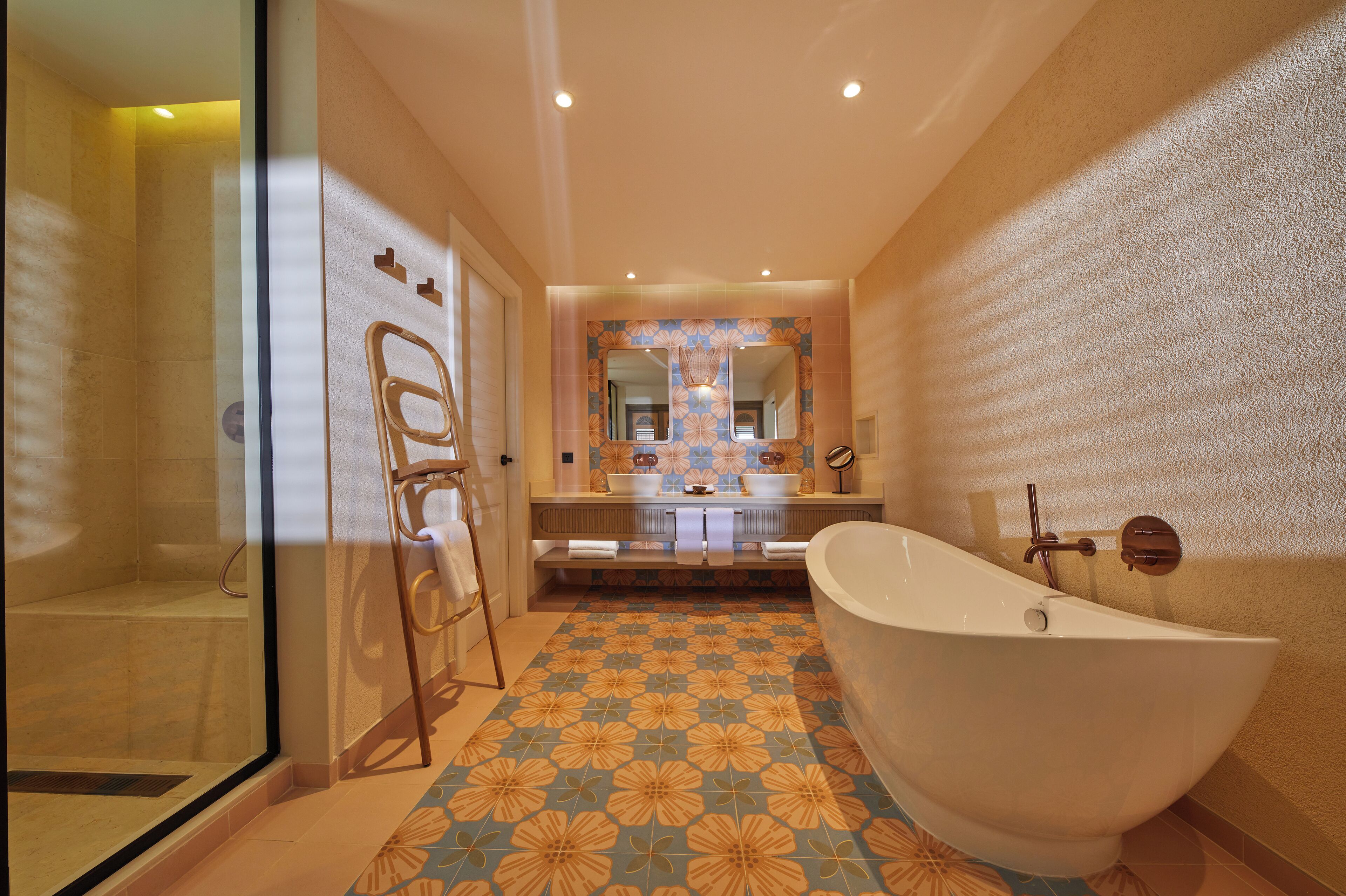 A bathroom with a freestanding bathtub, a glass shower enclosure, and a vanity with a large mirror.