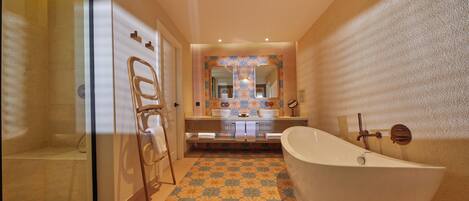 A bathroom with a freestanding bathtub, a glass shower enclosure, and a vanity with a large mirror.