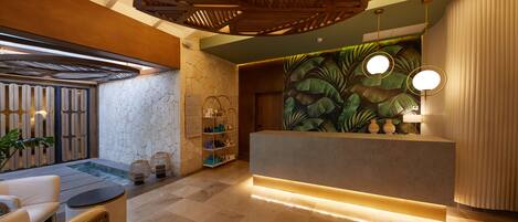 A reception area with a reception desk, seating area, and a wall mural.