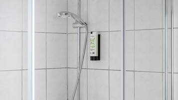 A shower area with a handheld showerhead, a wall-mounted control panel, and a glass-enclosed shower stall.