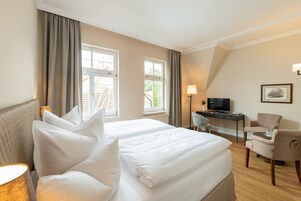 Ropa de cama hipoalergénica y caja de seguridad en la habitación 