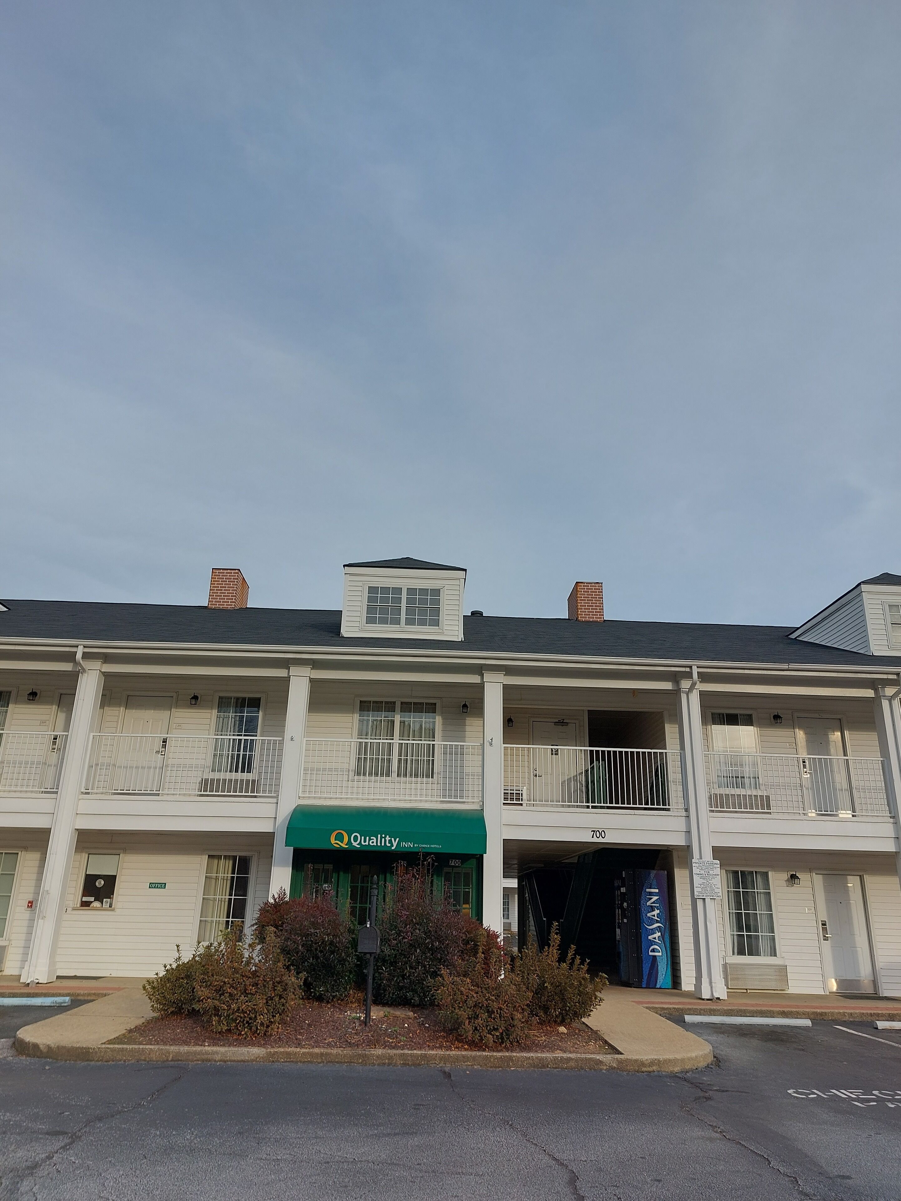 A two-story building with a green awning labeled "Quality Inn by Wyndham."