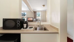A compact kitchen with a microwave, coffee maker, and sink. - Travelodge by Wyndham Downtown Chicago (Chicago)