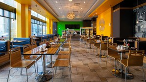 A restaurant with booths, tables, and a green wall in the background. - Travelodge by Wyndham Downtown Chicago (Chicago)