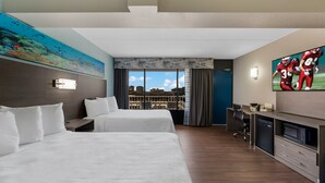 A hotel room with two beds, a desk with a microwave, a TV, and a city view. - Red Roof Inn PLUS+ & Suites Virginia Beach – Seaside (Virginia Beach)