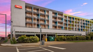 A multi-story hotel with a flat facade, balconies, and a parking garage. - Red Roof Inn PLUS+ & Suites Virginia Beach – Seaside (Virginia Beach)