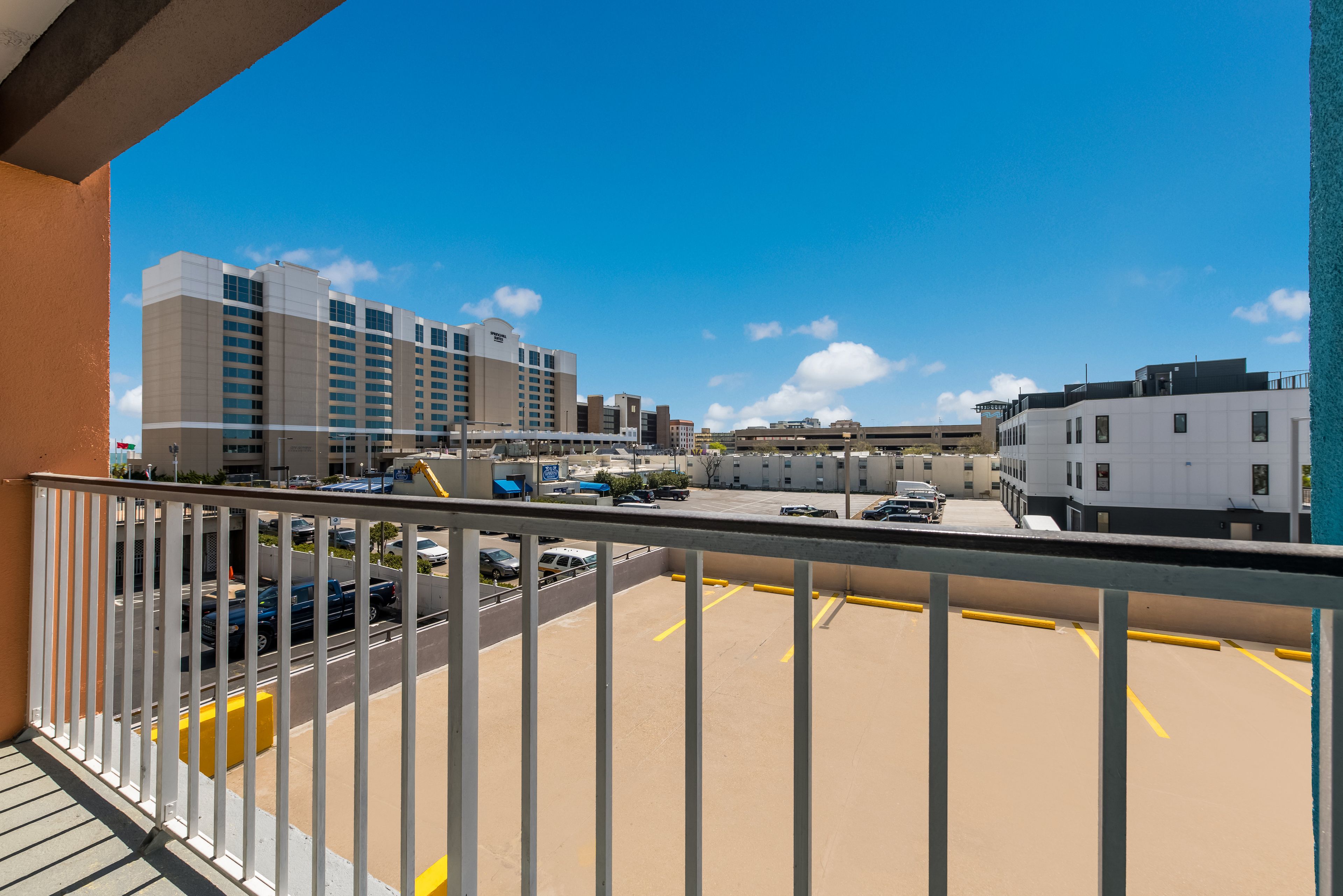 A parking area with a view of a hotel and other buildings.