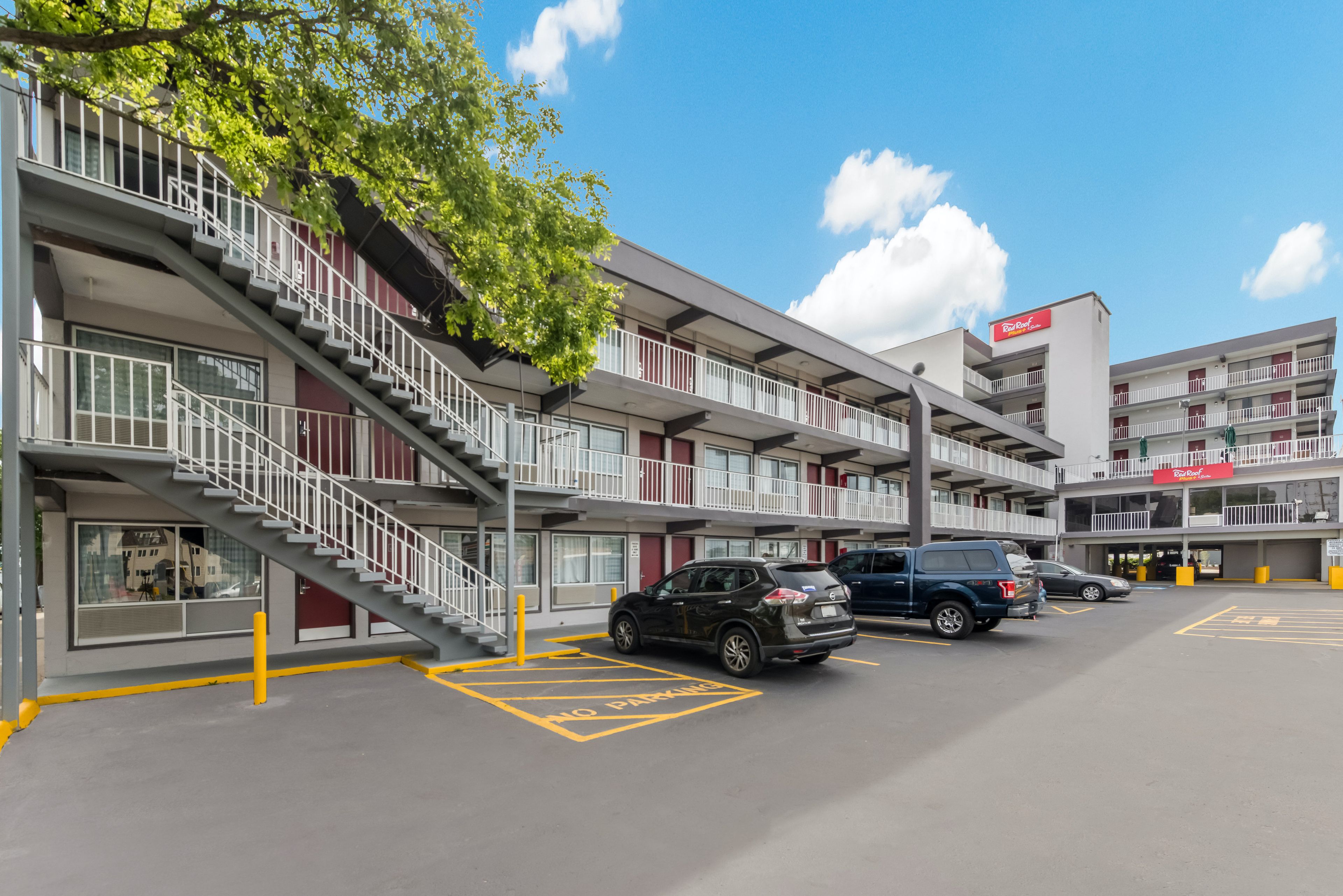 A multi-story parking garage with a no parking sign, a staircase, and a Red Roof restaurant sign.