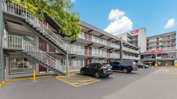 A multi-story parking garage with a no parking sign, a staircase, and a Red Roof restaurant sign.