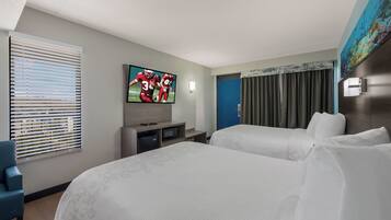 A hotel room with two beds, a television, a desk, and a window with blinds.