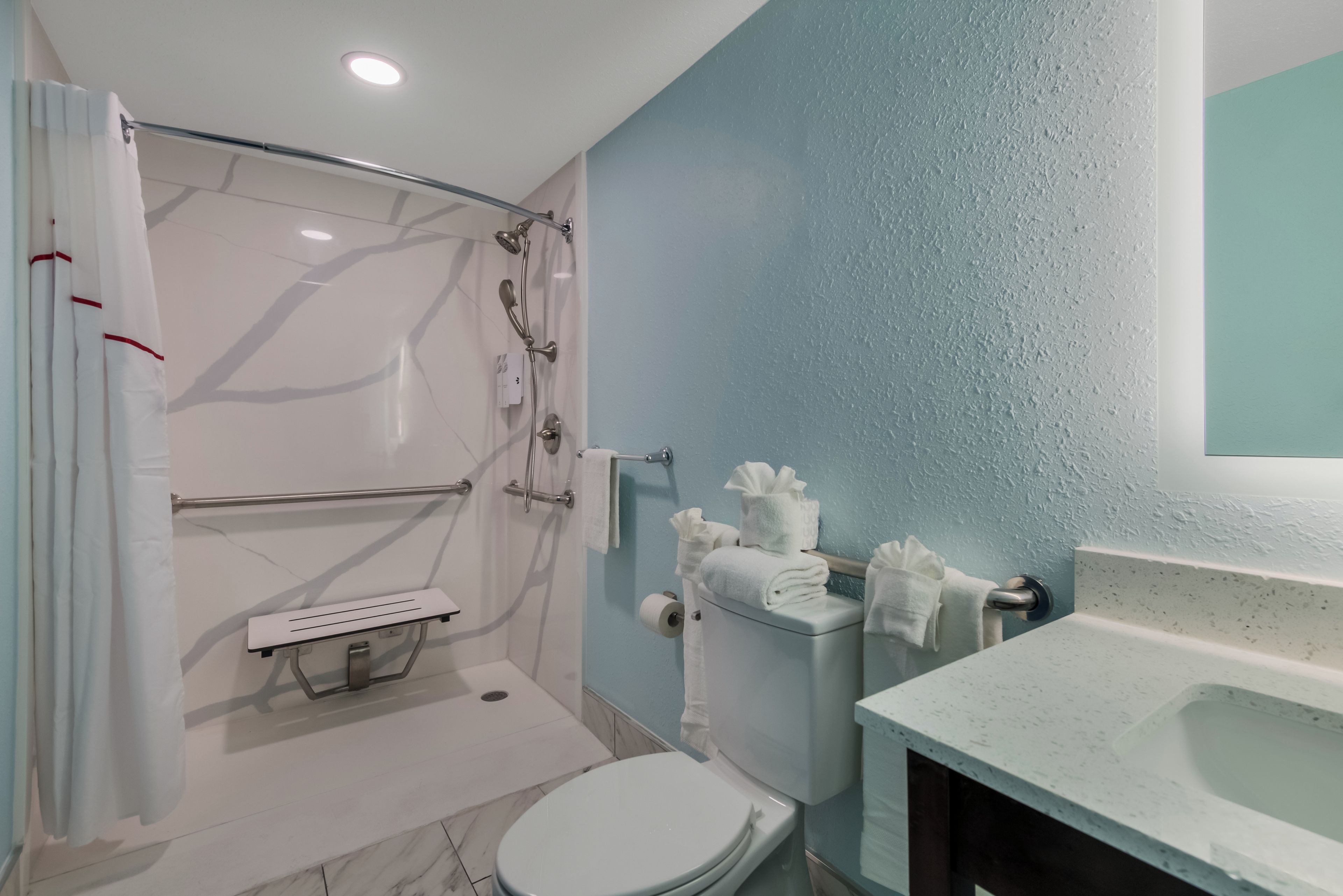 A bathroom with a shower, toilet, and sink.