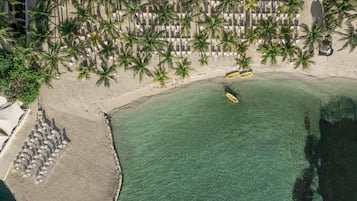 On the beach, white sand, sun loungers, beach umbrellas