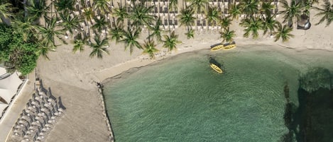 On the beach, white sand, sun loungers, beach umbrellas