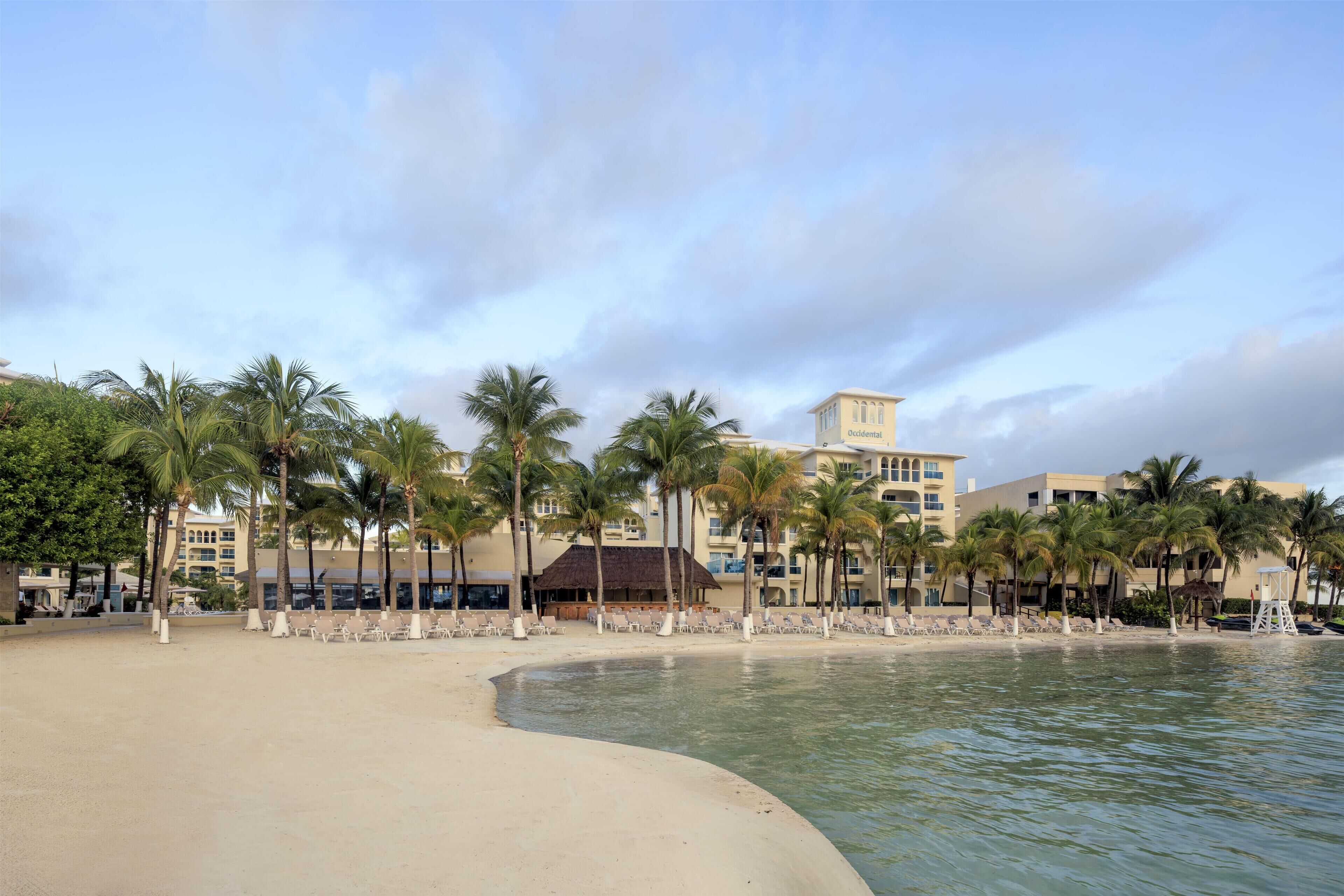 A beachside resort with palm trees, a sandy beach, and a building labeled "Residential."