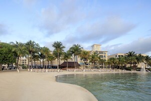 Un resort frente a la playa con palmeras, una playa de arena y un edificio con la leyenda 'Residential'.