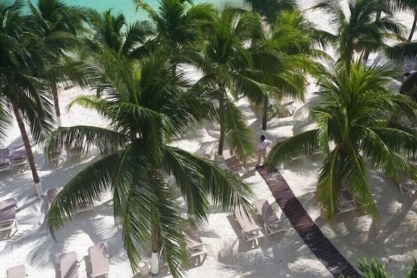 On the beach, white sand, sun loungers, beach umbrellas