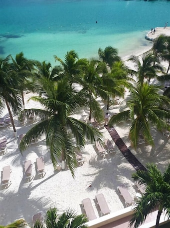 Ubicación a pie de playa, arena blanca, tumbonas y sombrillas. Occidental Costa Cancún All Inclusive