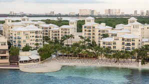Un resort con varias edificaciones, una playa y una masa de agua.