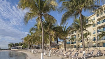 On the beach, white sand, sun loungers, beach umbrellas