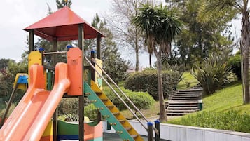 Children can play on the playground's slide and climbing elements.