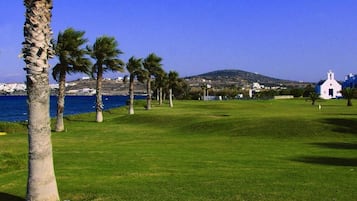 Escape to a serene golf course with a tranquil sea view and lush green surroundings.