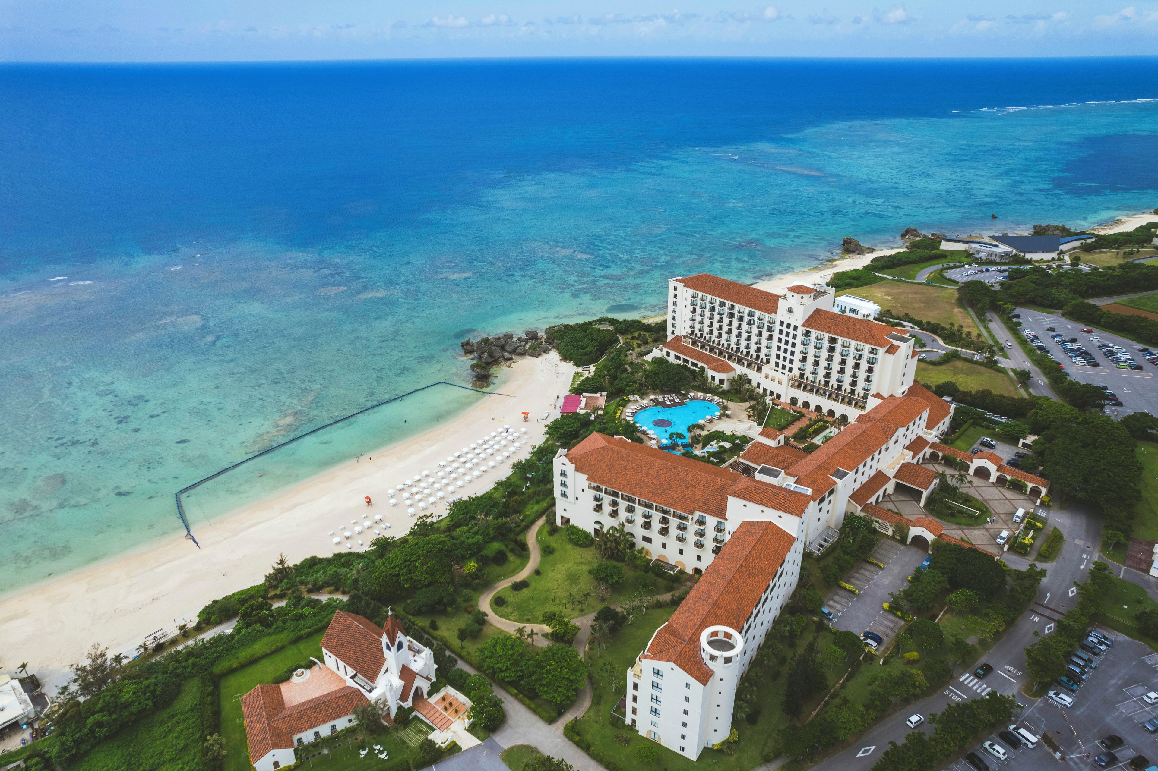 Un resort con varias edificaciones, una playa y una piscina.