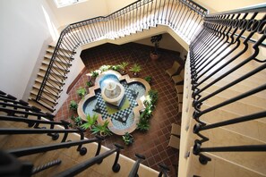 A spiral staircase with a central fountain and potted plants. - Hotel Nikko Alivila (Yomitan)