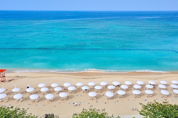 On the beach, white sand, beach umbrellas, beach towels
