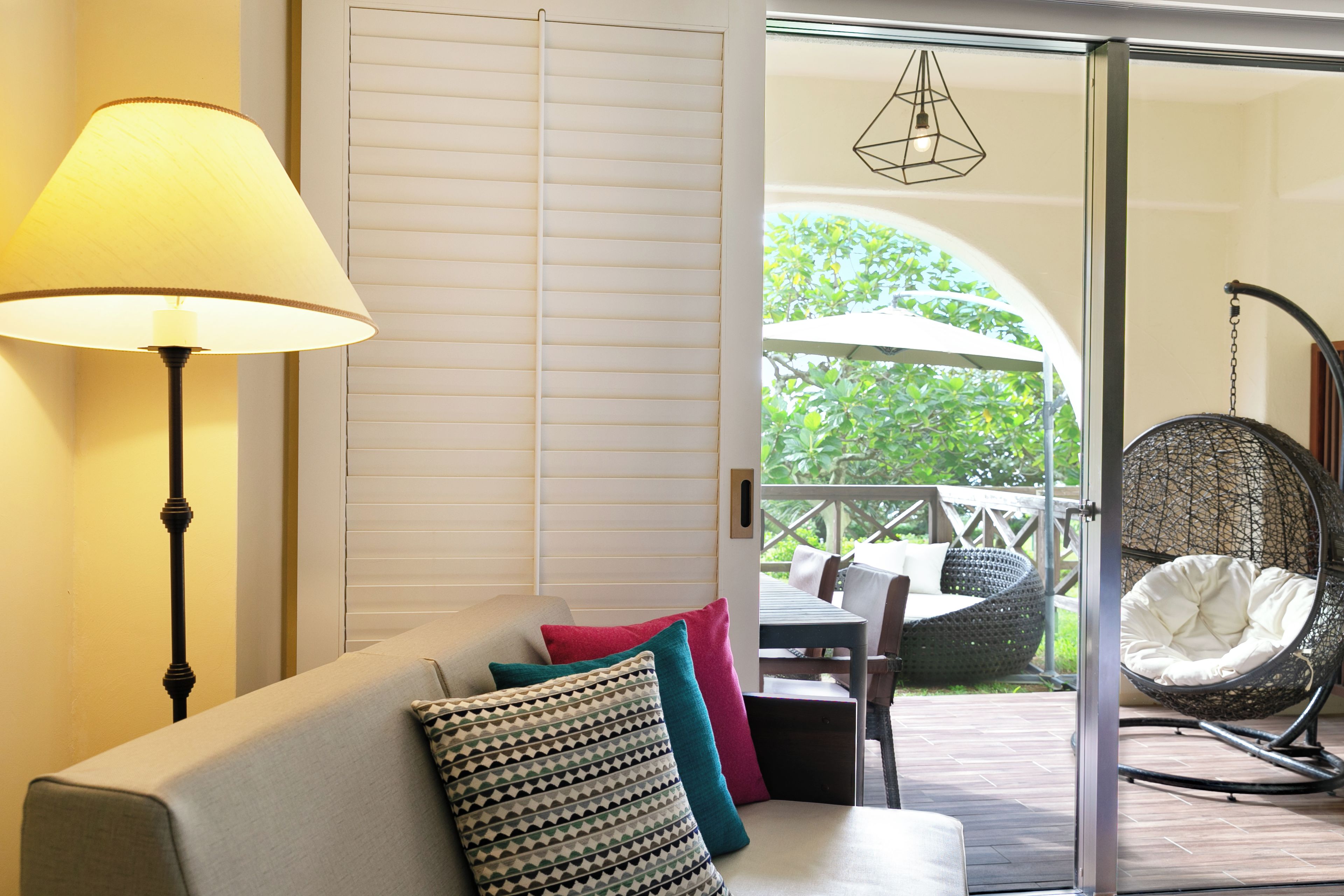 Una habitación con sofá, sillón colgante y vistas al exterior.