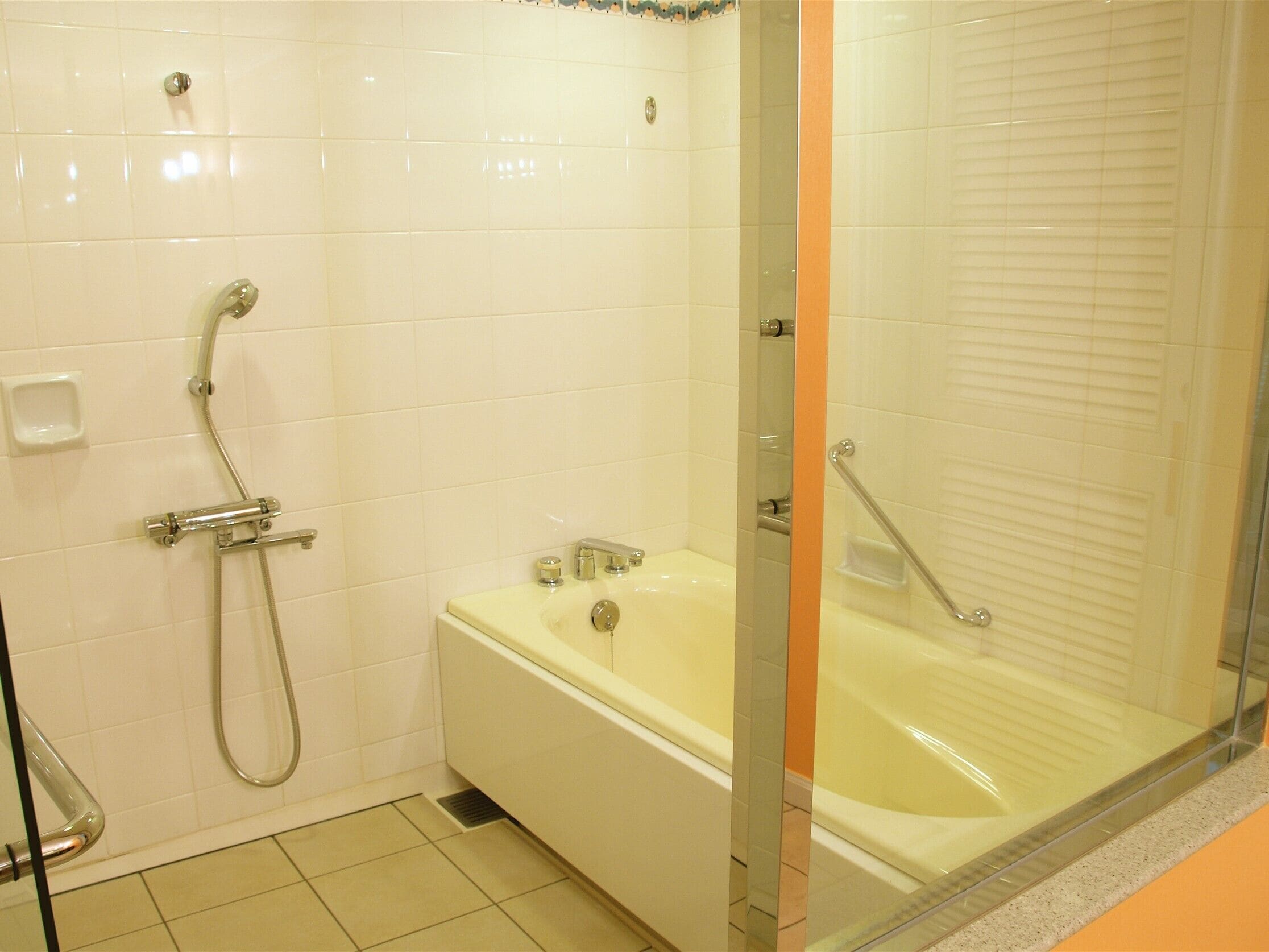 Un baño con bañera, ducha y cabina de ducha con mampara de vidrio.