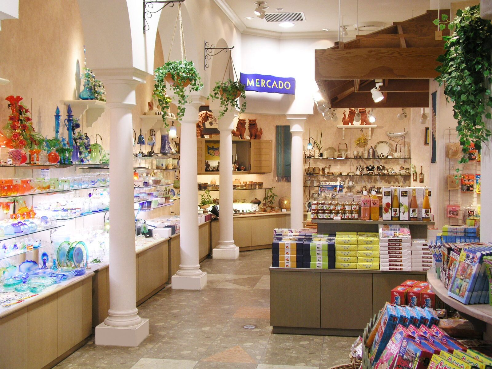 A well-lit store with various items on shelves, including glassware and boxes.