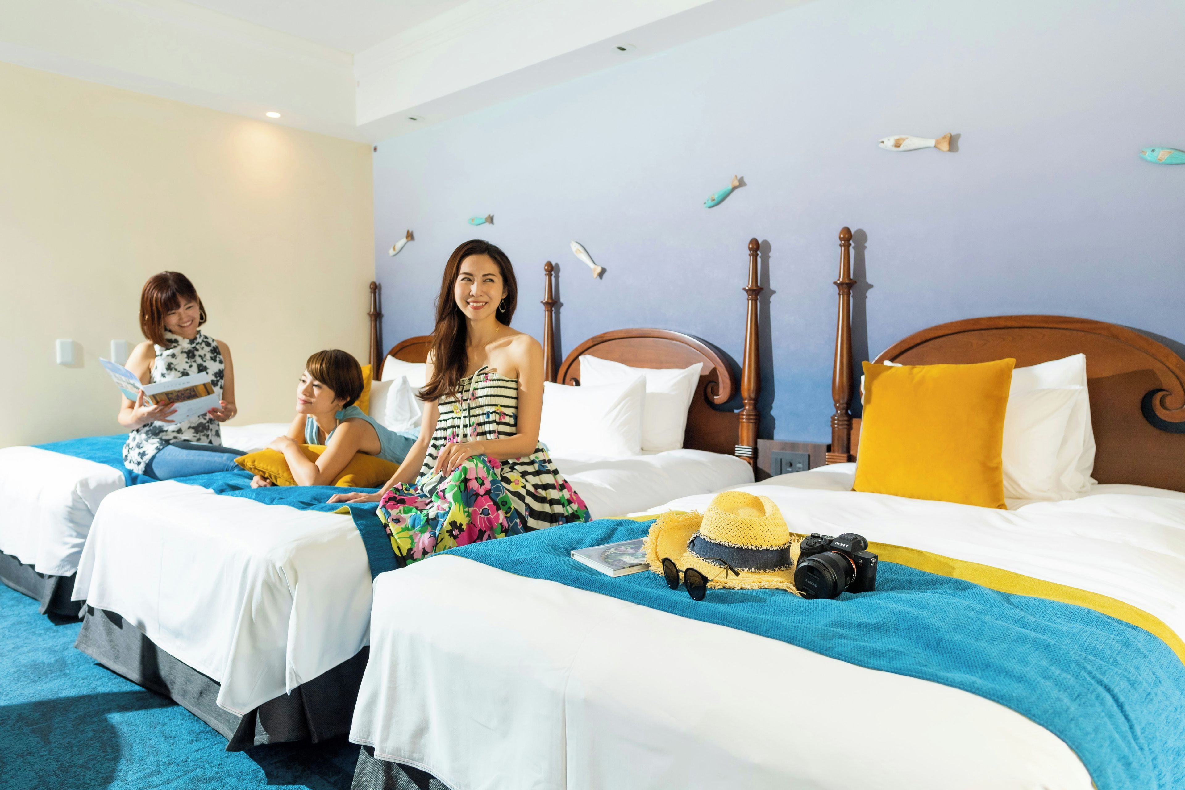 Ein Hotelzimmer mit zwei Betten, einem Holzkopfende und einem blauen Teppich.