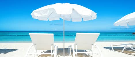 On the beach, white sand, beach umbrellas, beach towels