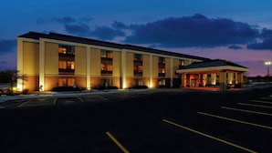 A multi-story hotel with a flat roof, a covered entrance, and a parking lot. - Elgin Inn (Elgin)