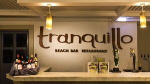 A bar counter with a sign reading "tranquillo beach bar restaurant" and various bottles and a beer tap. - Aeolos Beach Hotel (Kos)