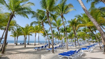On the beach, white sand, sun-loungers, beach umbrellas