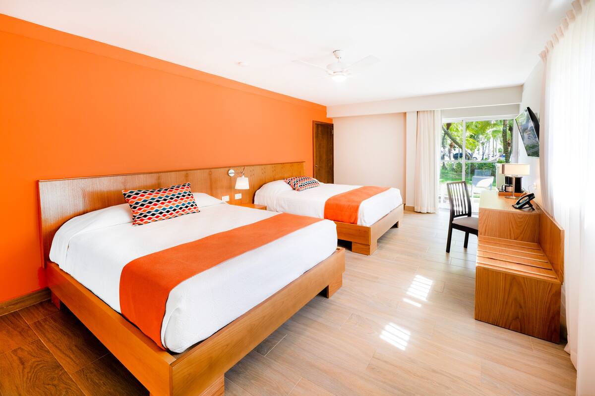 Une chambre d’hôtel avec deux lits, un bureau et une chaise.