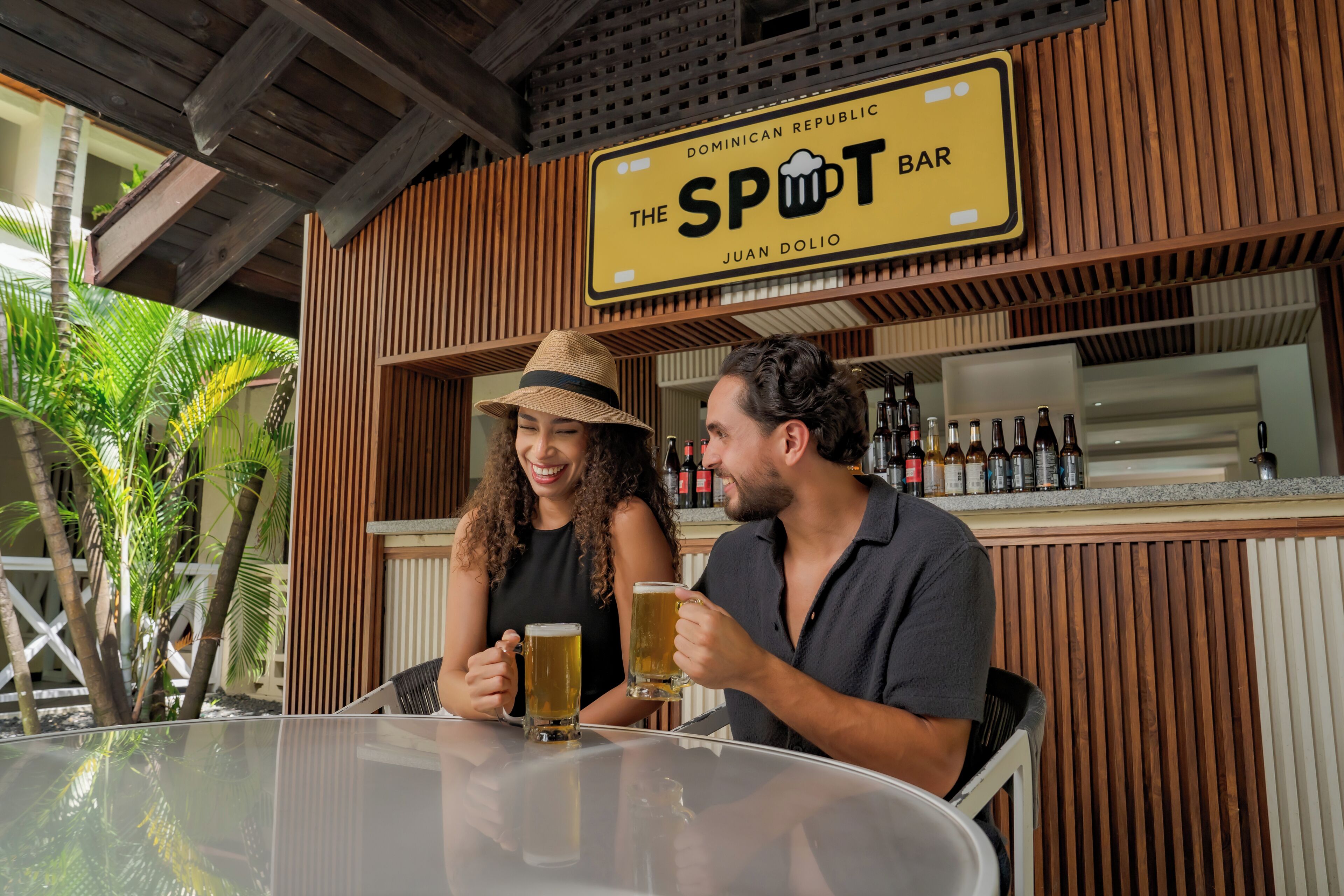 A bar named "The Spot Bar" with a wooden interior and a tropical outdoor setting.