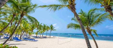 Aan het strand, wit zand, ligstoelen aan het strand, parasols