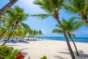 On the beach, white sand, sun loungers, beach umbrellas
