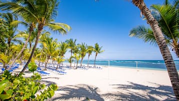 On the beach, white sand, sun loungers, beach umbrellas