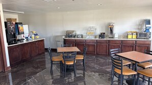A clean, well-lit kitchen area with a coffee machine, microwave, and a food display. - Days Inn by Wyndham Fort Stockton (Fort Stockton)