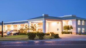 A hotel with multiple balconies, a covered parking area, and a well-lit entrance. - Days Inn by Wyndham Fort Stockton (Fort Stockton)